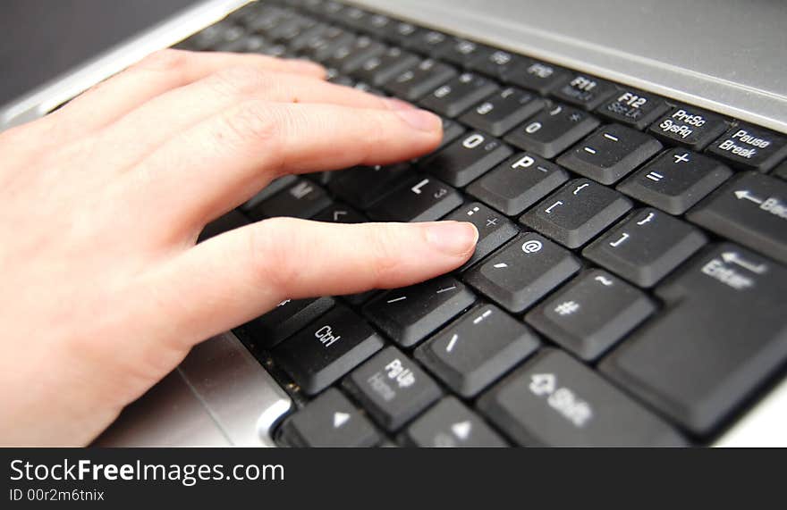 Hand typing on a black keyboard. Hand typing on a black keyboard