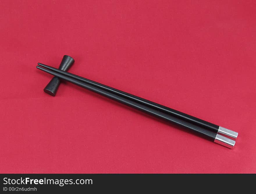 Chopsticks for a sushi on a red background