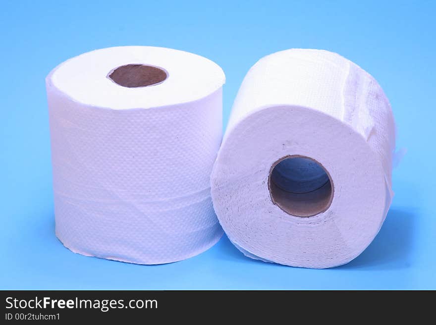 Two white toilet rolls on a bright blue background. Two white toilet rolls on a bright blue background.