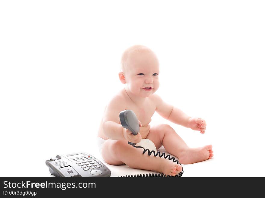 Little smiling baby with telephone receiver in hand over white background