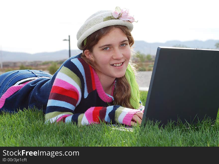 Young girl is working on laptop at outdoor location. Young girl is working on laptop at outdoor location