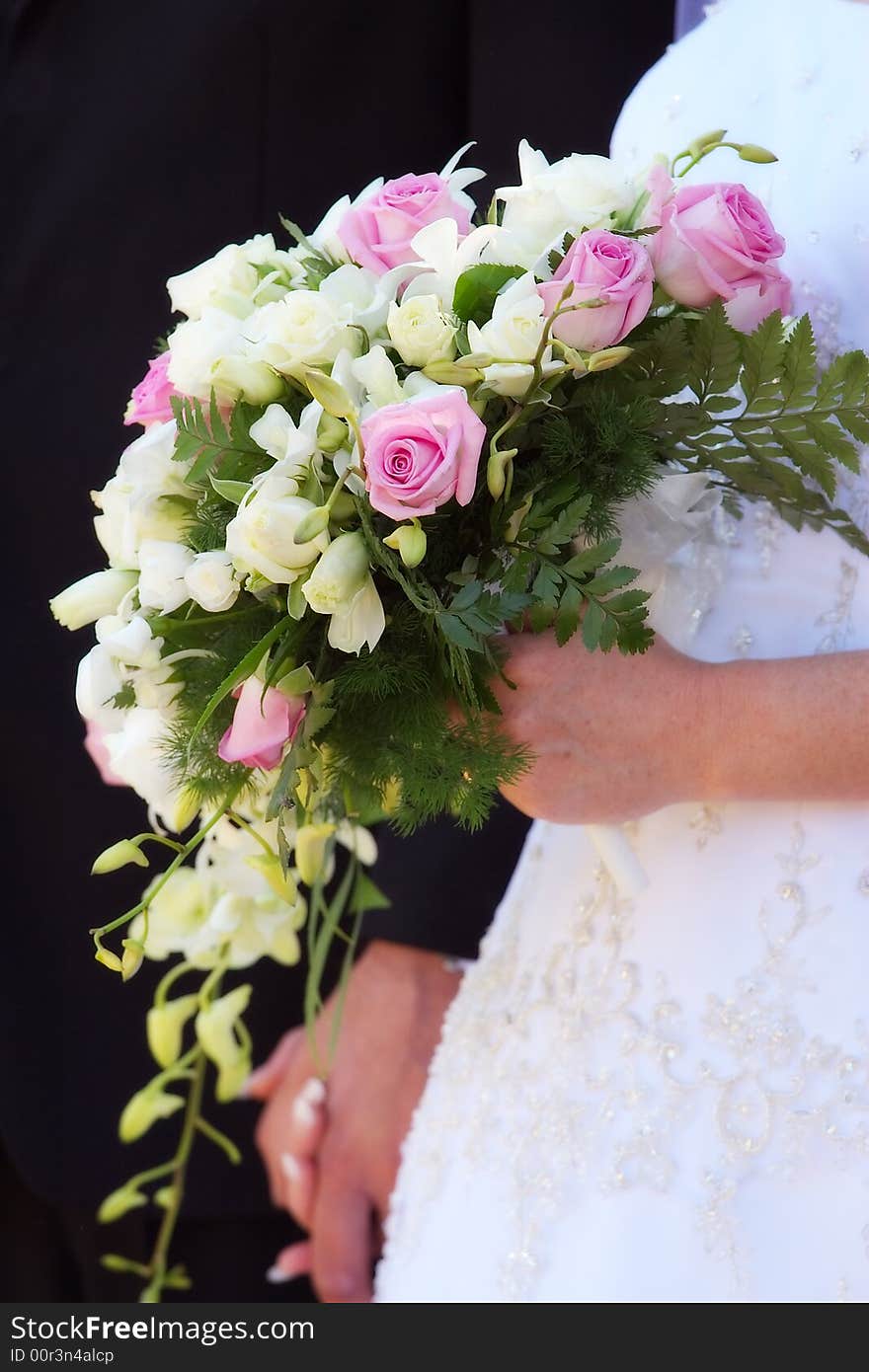 A bride with her bouquet in one hand, grooms hand in the other. A bride with her bouquet in one hand, grooms hand in the other.