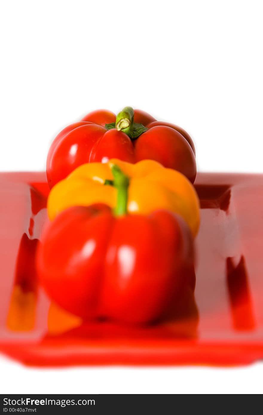 Macro of Bellpeppers on a red plate on a white background. Macro of Bellpeppers on a red plate on a white background.