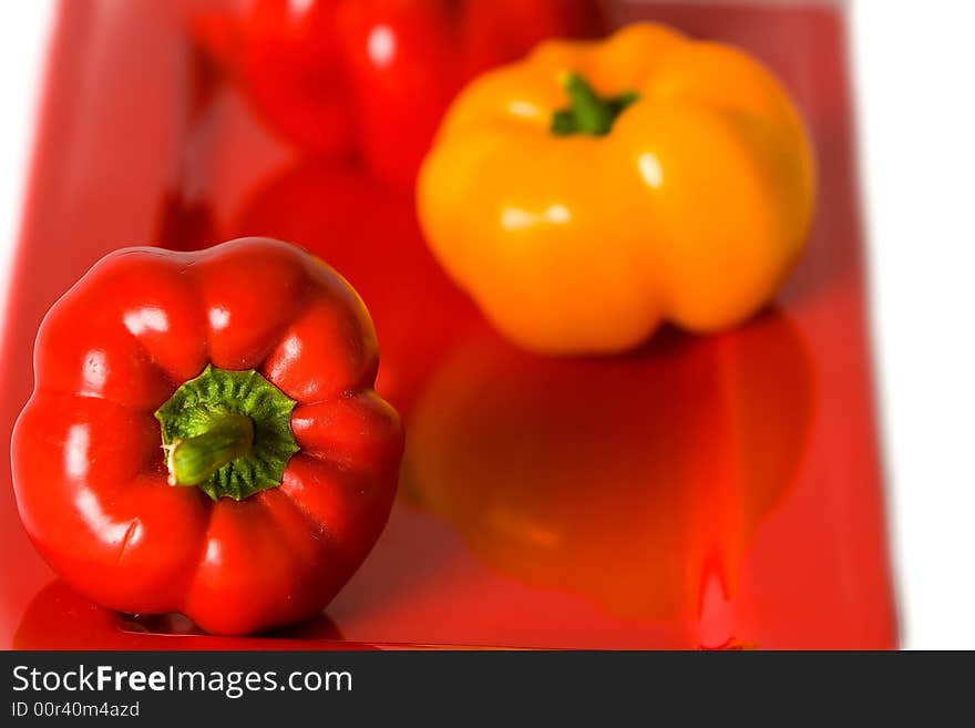 Bellpeppers on a red serving dish with a white background. Bellpeppers on a red serving dish with a white background.