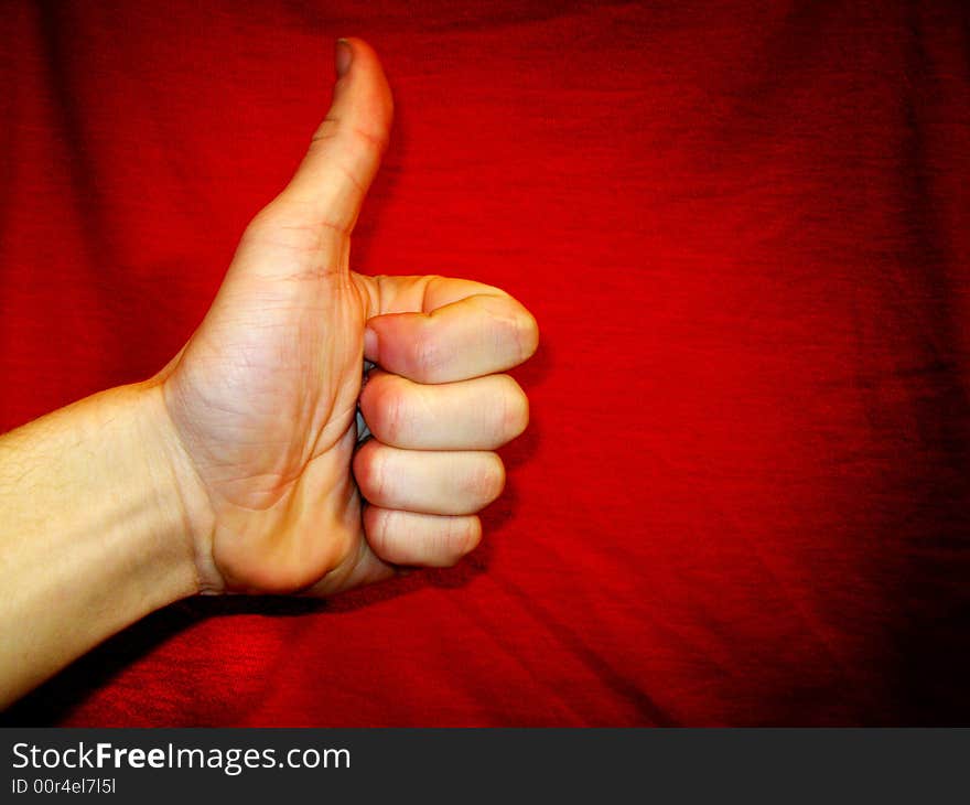 Hand showing success sign over red background