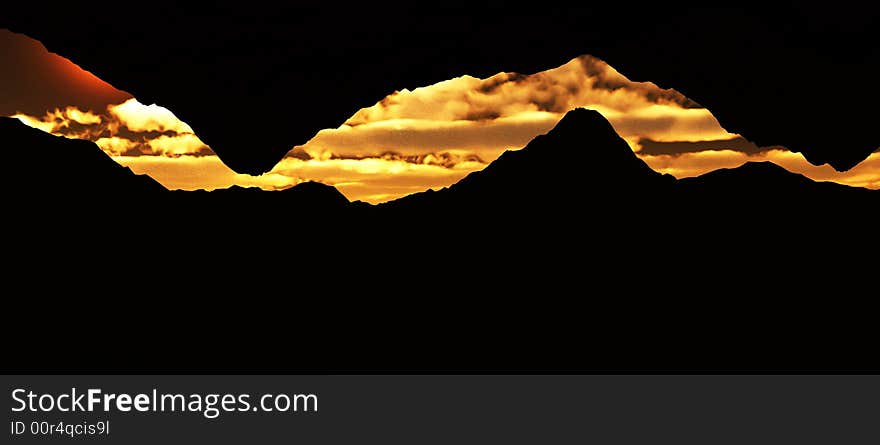 An panoramic image of a cave opening looking out towards a sky.