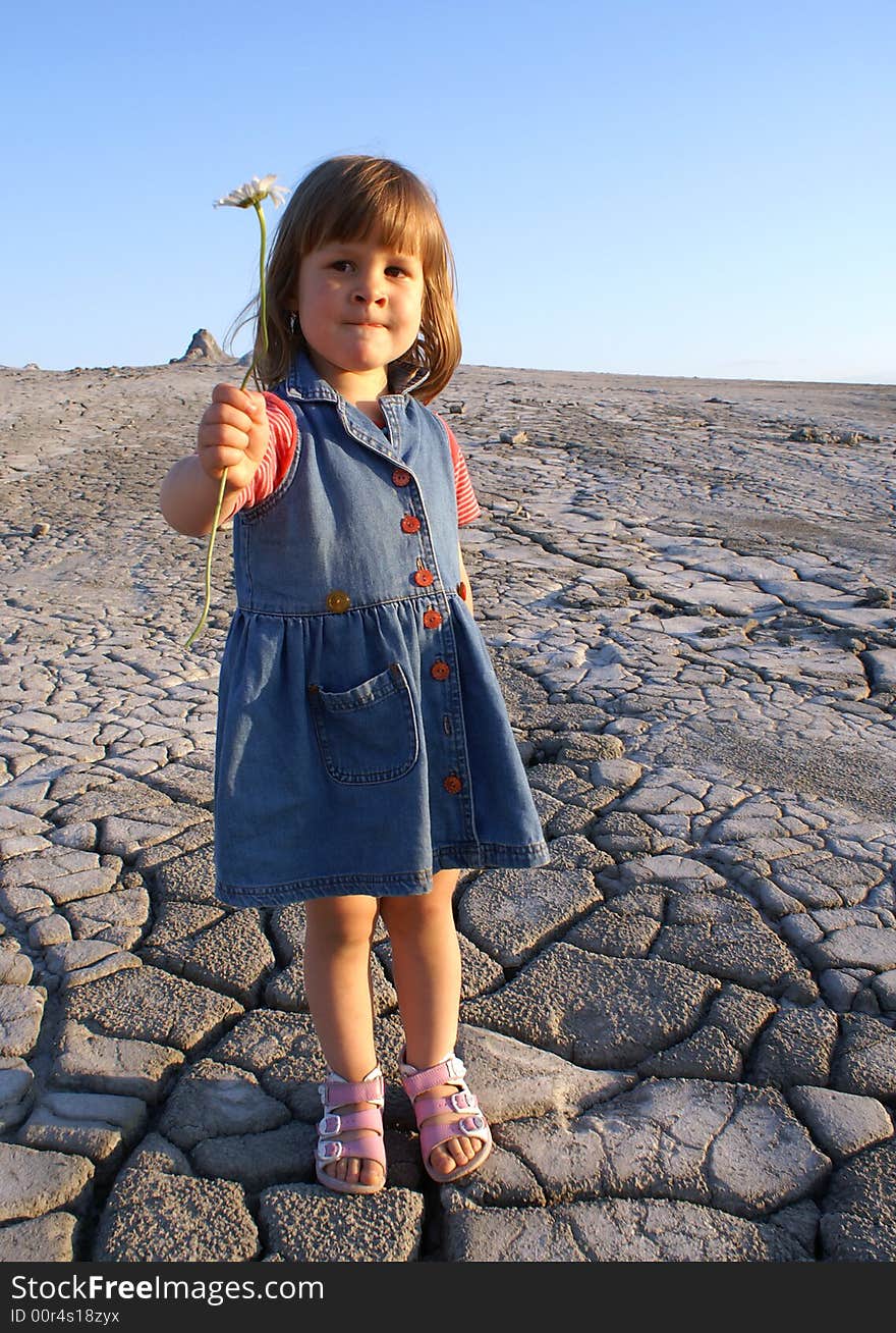 Girl with daisy standing in the dried fields of the Muddy Volcanoes (Vulcanii noroiosi). Girl with daisy standing in the dried fields of the Muddy Volcanoes (Vulcanii noroiosi)