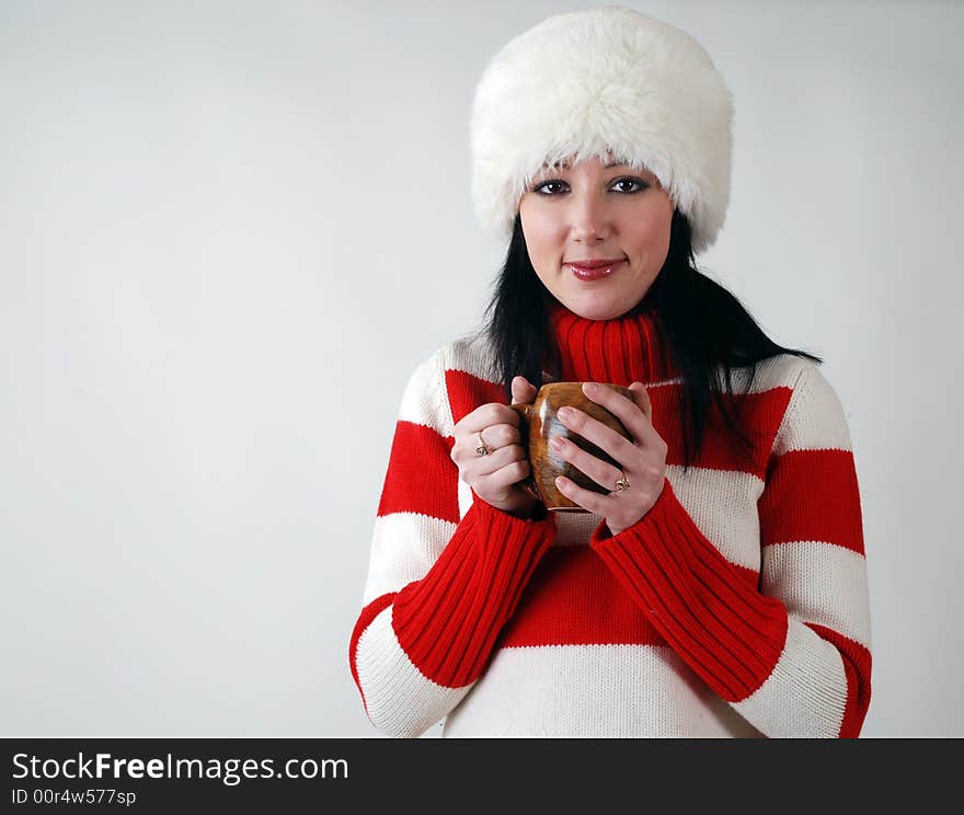 Winter portrait of young beautiful girl in fluffy hat with hot cup. Winter portrait of young beautiful girl in fluffy hat with hot cup