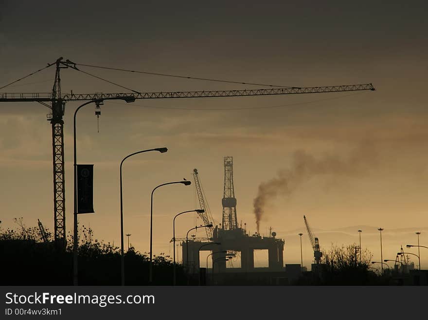 A silhouette of a oil rig and a crane. A silhouette of a oil rig and a crane