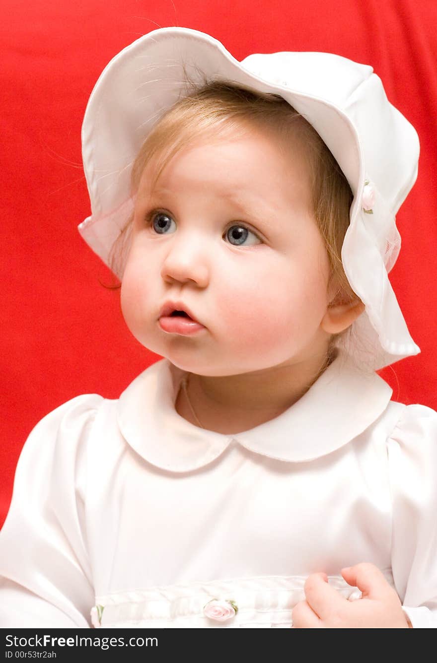 Little girl in white clothes on a red background