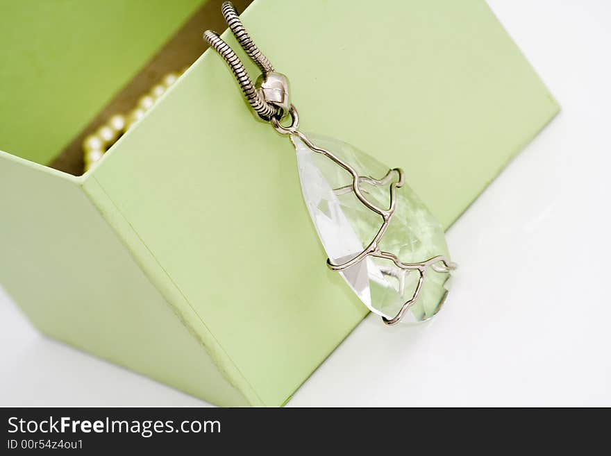 Green gift box with diamond necklace on white