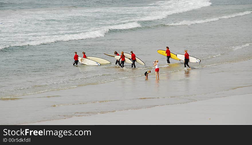 A family going surfing with red top wet suit. A family going surfing with red top wet suit