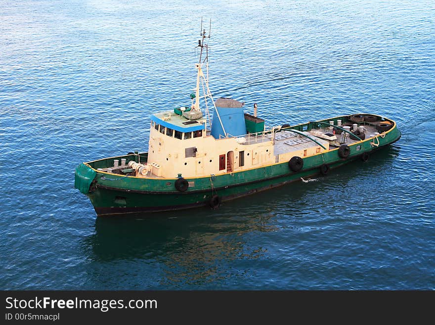 Caribbean harbor pilot tug boat helping cruise ship into its berth