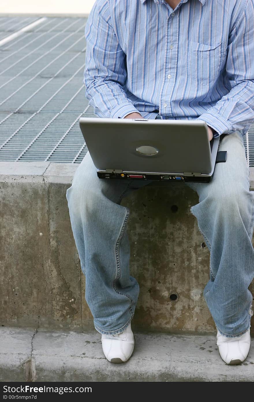 Young man sitting while typing on laptop. Young man sitting while typing on laptop