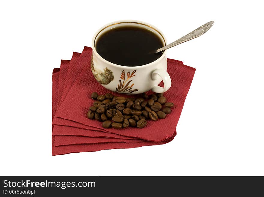 An isolated cup of hot coffee on a red napkin with some coffee-beans. An isolated cup of hot coffee on a red napkin with some coffee-beans