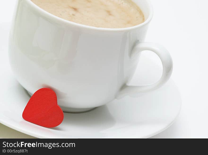 Coffee cup with coffee and small red heart on white background. Coffee cup with coffee and small red heart on white background.