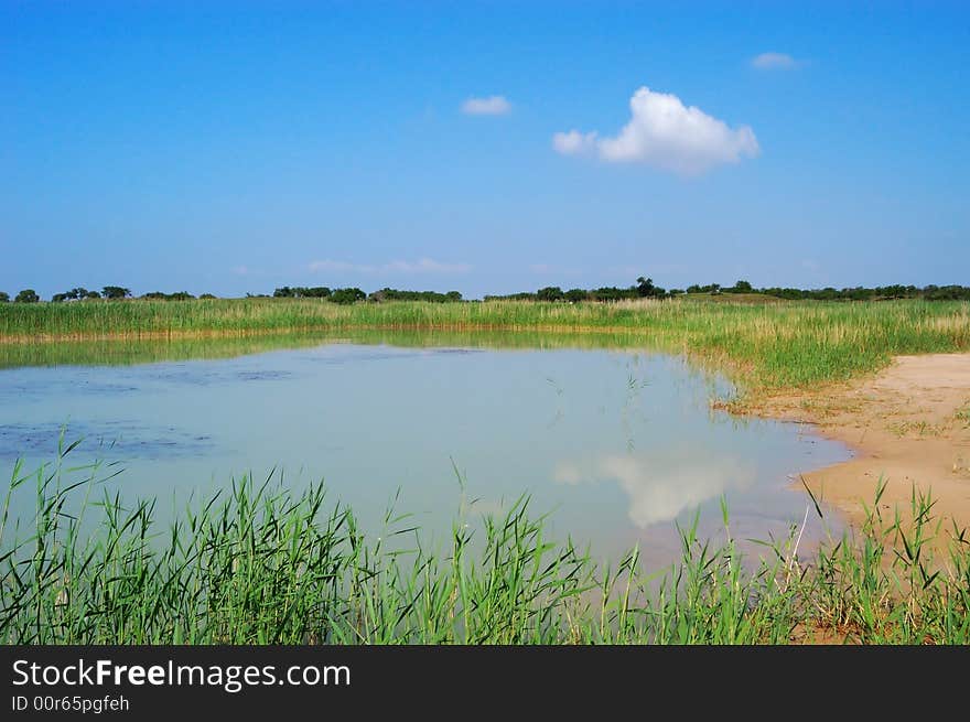 Light cloud in blue sky， inverted reflection in lake water. Light cloud in blue sky， inverted reflection in lake water