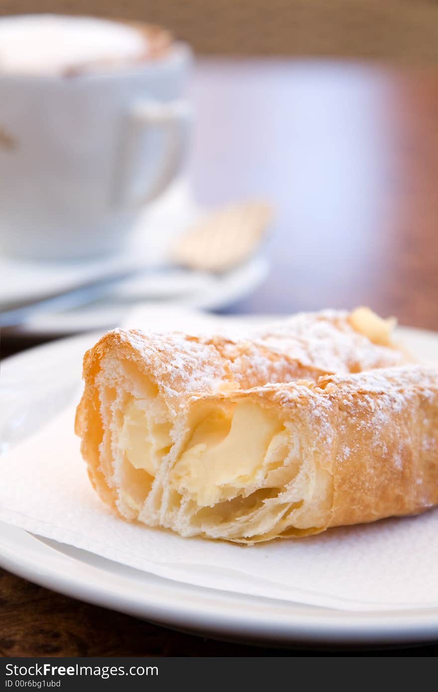 Cappuccino and delicious pastry on cafe table