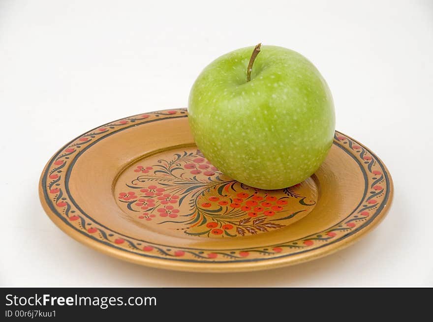 Green apple on a colour wooden plate. Green apple on a colour wooden plate.