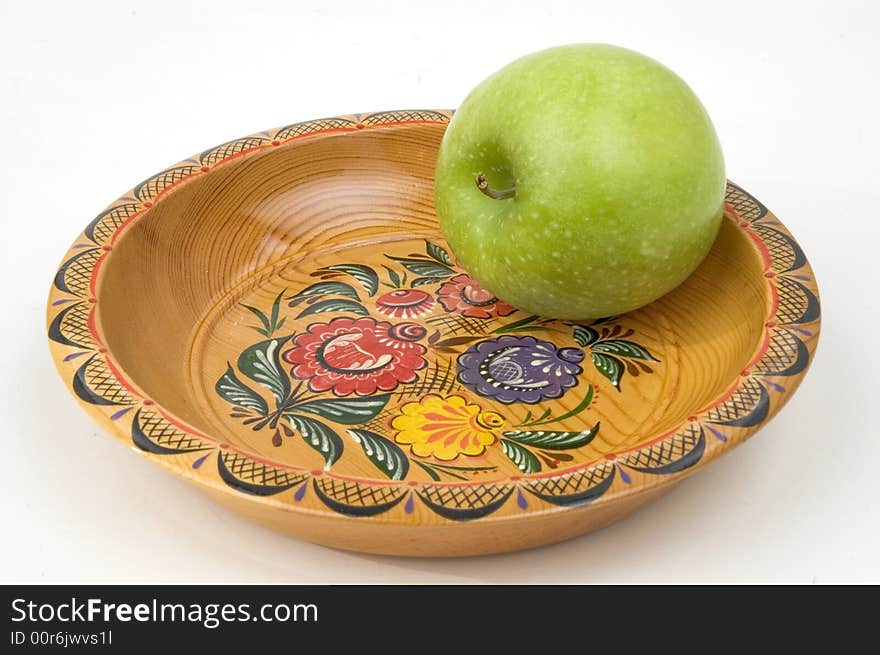 Green apple on a colour wooden plate. Green apple on a colour wooden plate.