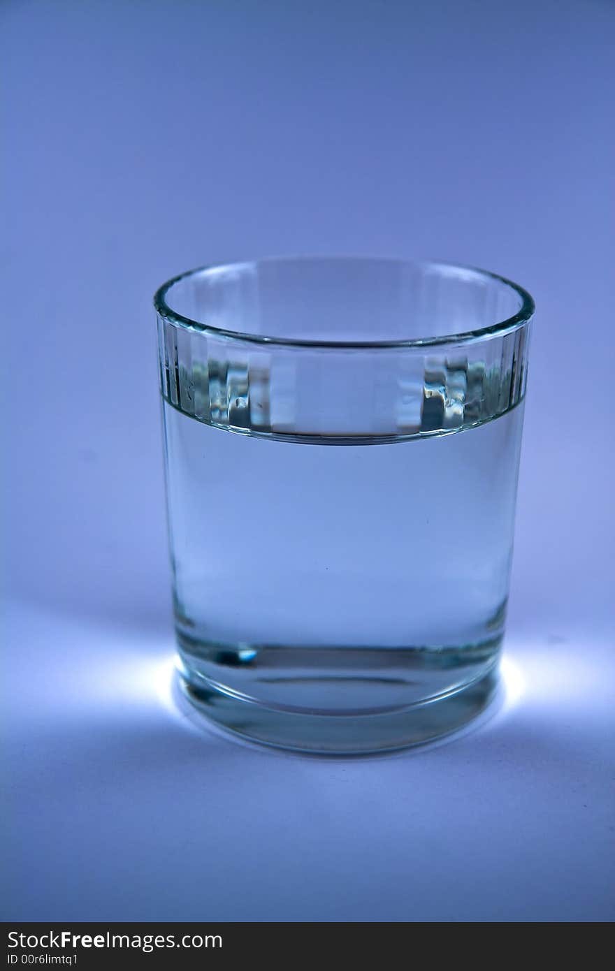 Single glass of water in blue colur macro