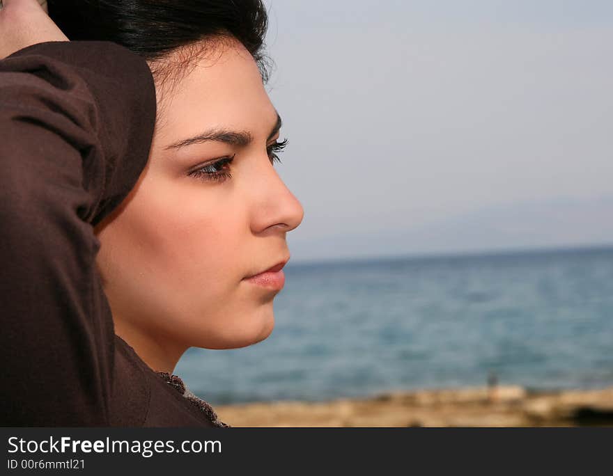 A young brunette woman portrait at the beach. A young brunette woman portrait at the beach