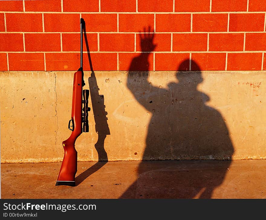 A rifle on the wall and a man's shadow. This versatile picture can be interpreted in many ways, with a lot of meanings. A rifle on the wall and a man's shadow. This versatile picture can be interpreted in many ways, with a lot of meanings