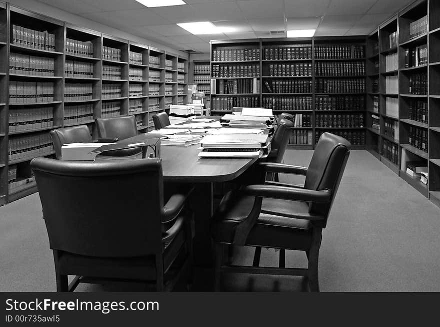 Conference room table with several leather chairs and shelves of books. Conference room table with several leather chairs and shelves of books