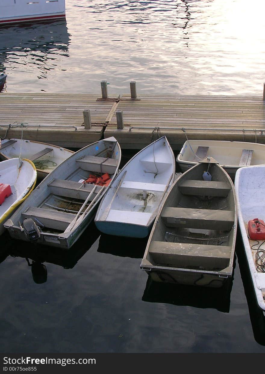 Rowboats rest in the harbor in Maine at dusk. Rowboats rest in the harbor in Maine at dusk