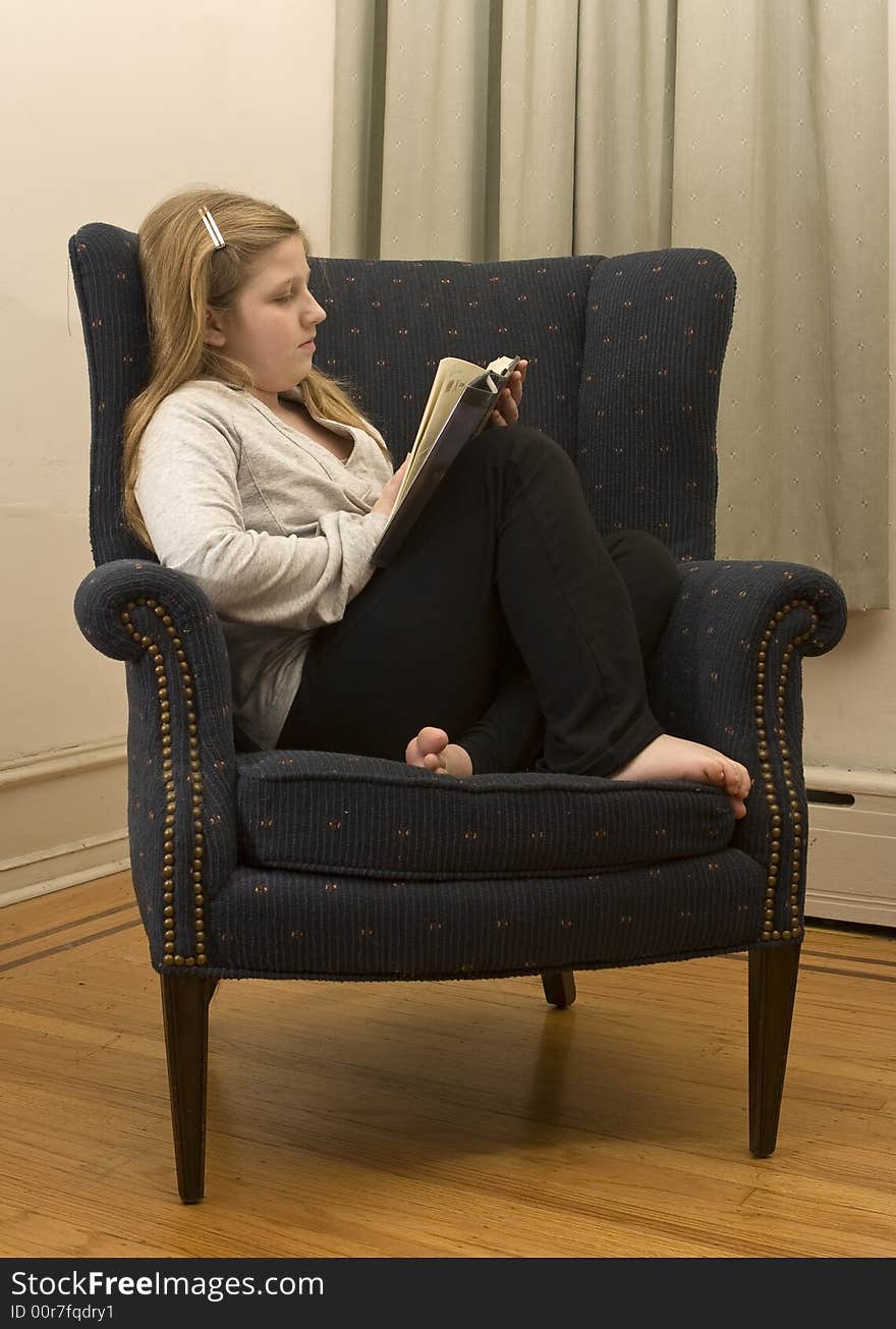 A young girl curling up with a good book. A young girl curling up with a good book