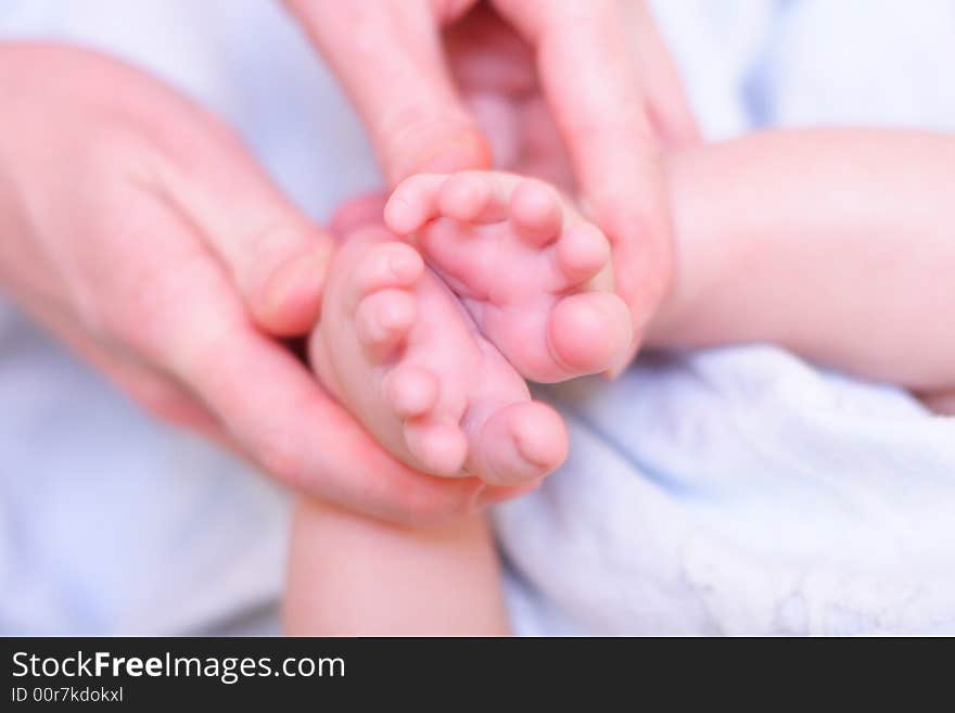 Mother hold baby leg in hand like shape of flower