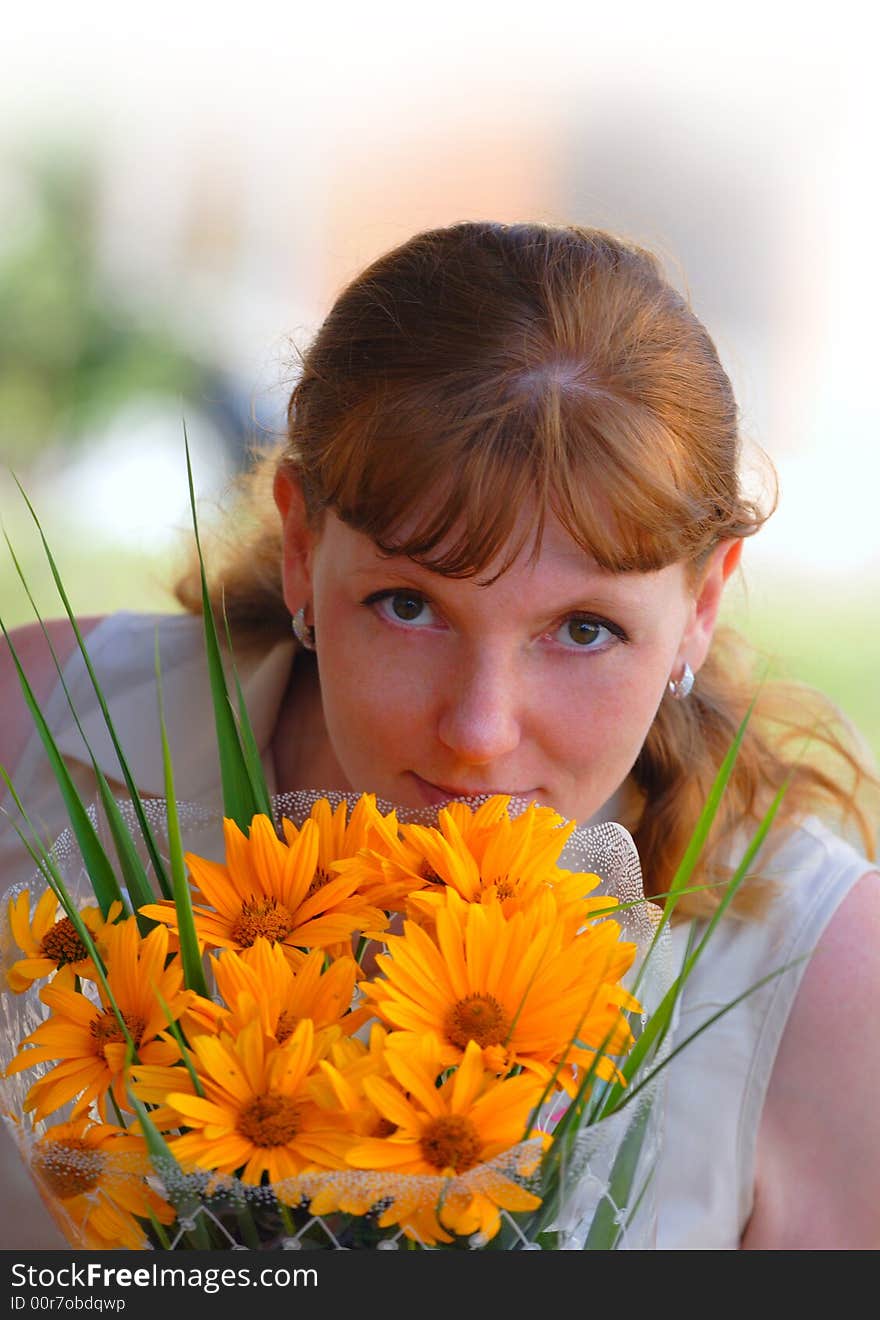 Woman with orange flowers look at camera. Woman with orange flowers look at camera