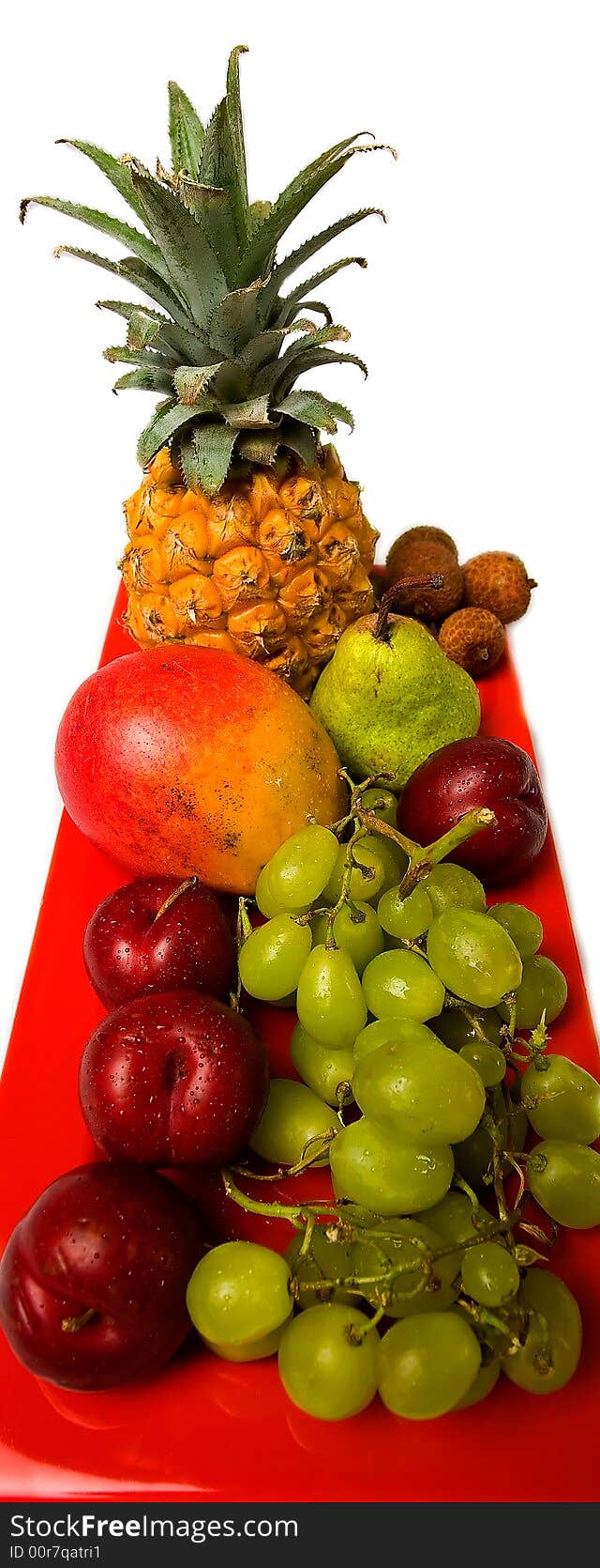 Assortment of fresh fruit arranged on a bright red serving dish. Assortment of fresh fruit arranged on a bright red serving dish.