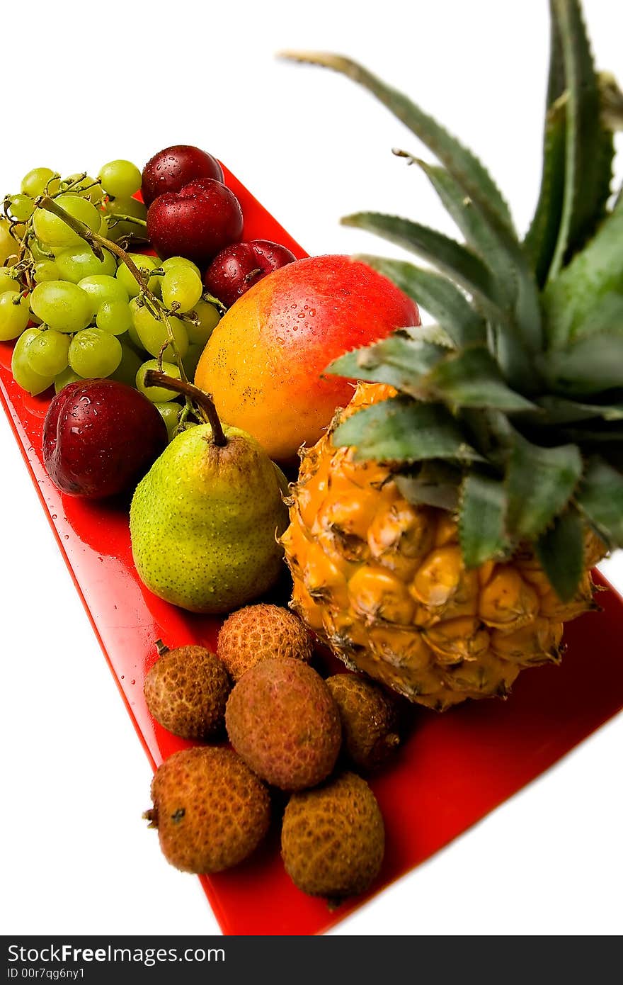 Assortment of fresh fruit arranged on a bright red serving dish. Assortment of fresh fruit arranged on a bright red serving dish.