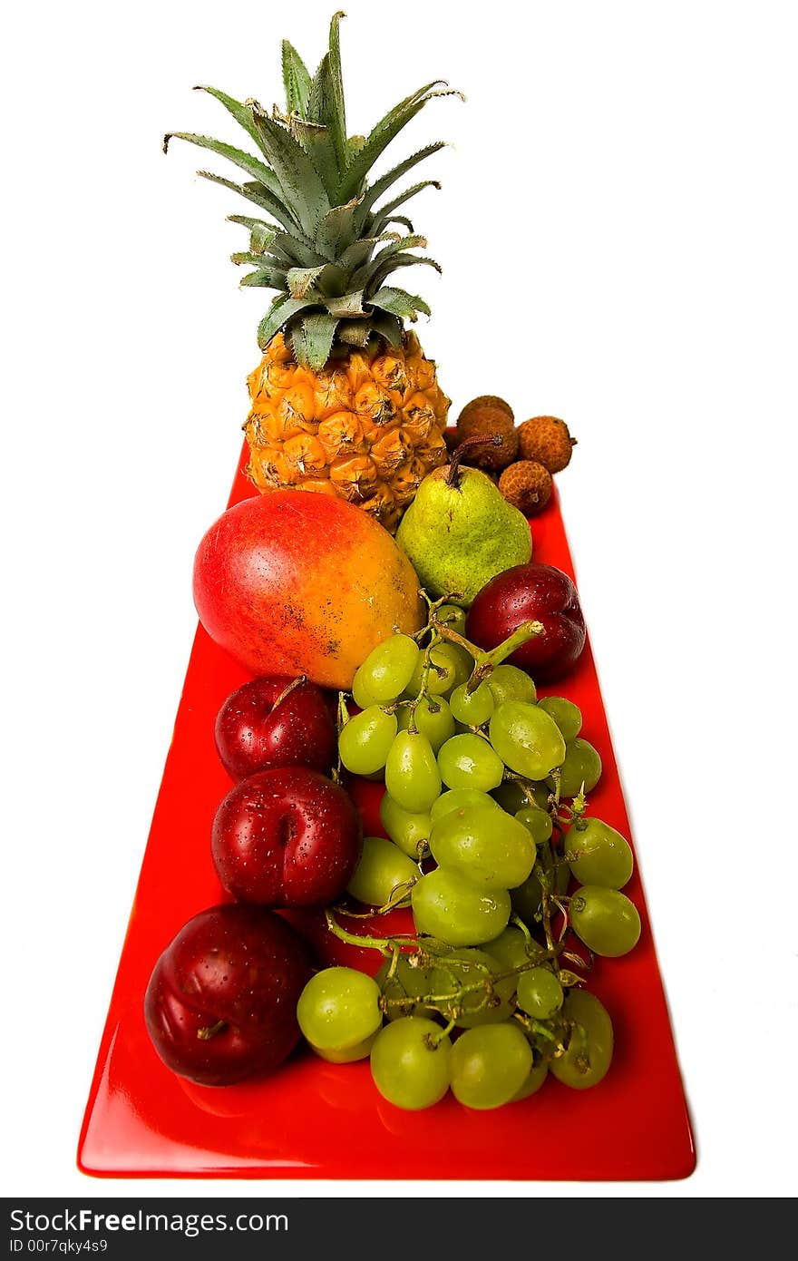 Assortment of fresh fruit arranged on a bright red serving dish. Assortment of fresh fruit arranged on a bright red serving dish.