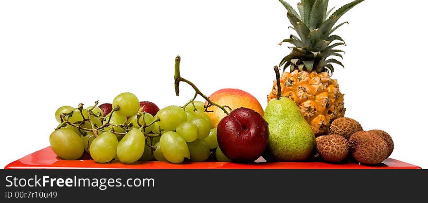 Assortment of fresh fruit arranged on a bright red serving dish. Assortment of fresh fruit arranged on a bright red serving dish.