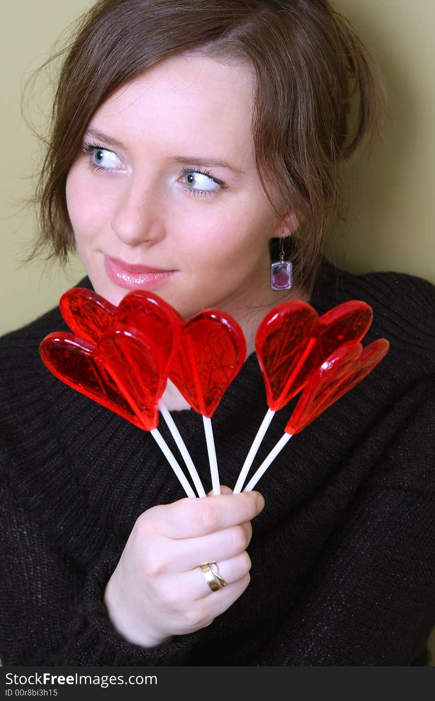 Valentine girl is holding lollipops in palm