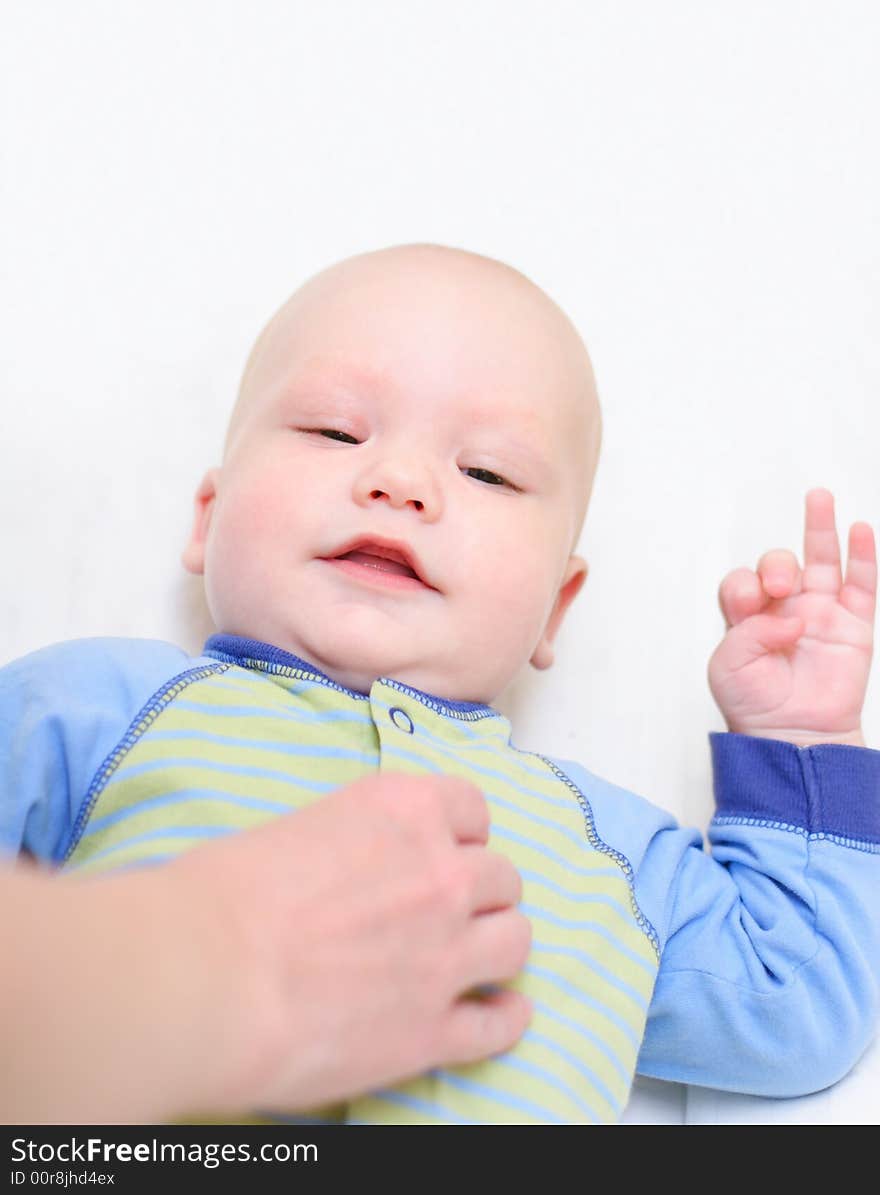 Baby lie on bed and smiling to his mother. Baby lie on bed and smiling to his mother