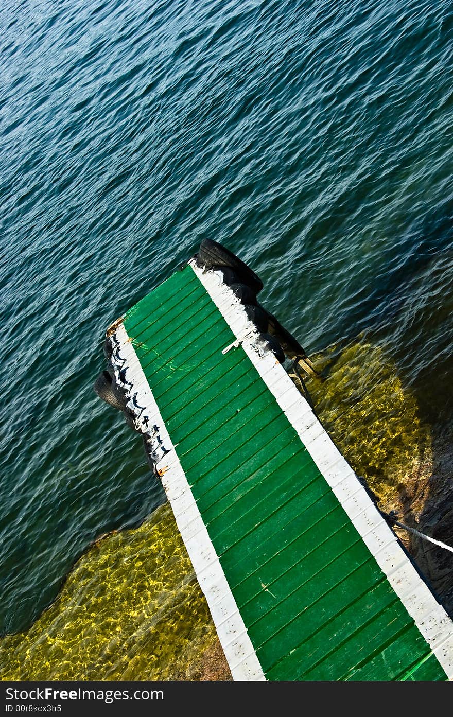 A green ramp leading to a lake.