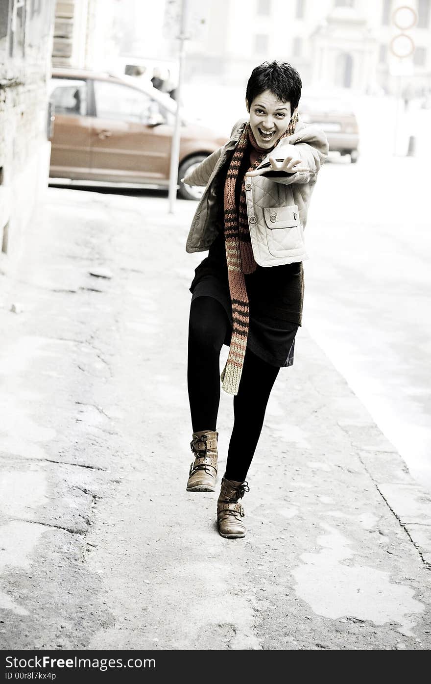 The young woman in a jump for joy on a public street.