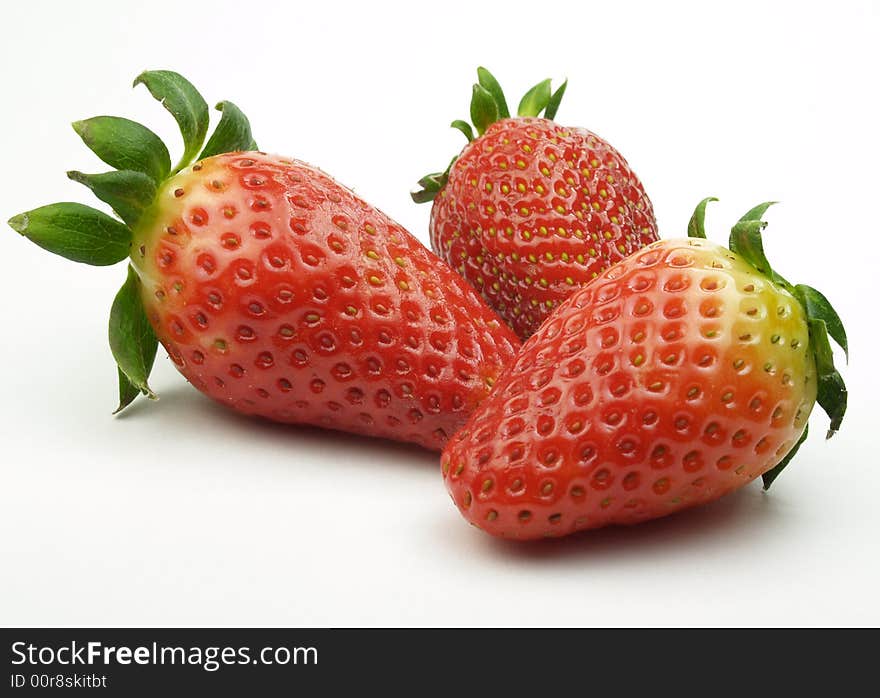 Three red strawberries isolated on white