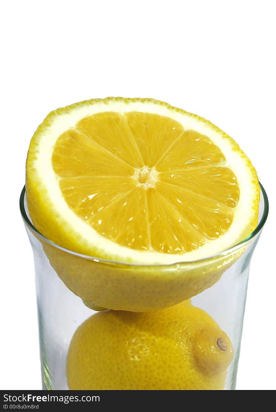 Two parts of yellow ripe lemon in the glass on white background. Two parts of yellow ripe lemon in the glass on white background