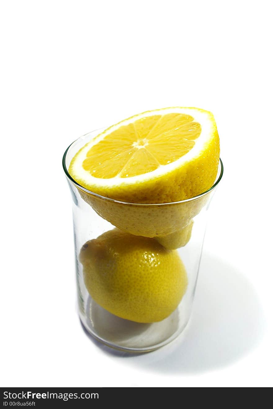 Two parts of yellow ripe lemon in the glass on white background. Two parts of yellow ripe lemon in the glass on white background