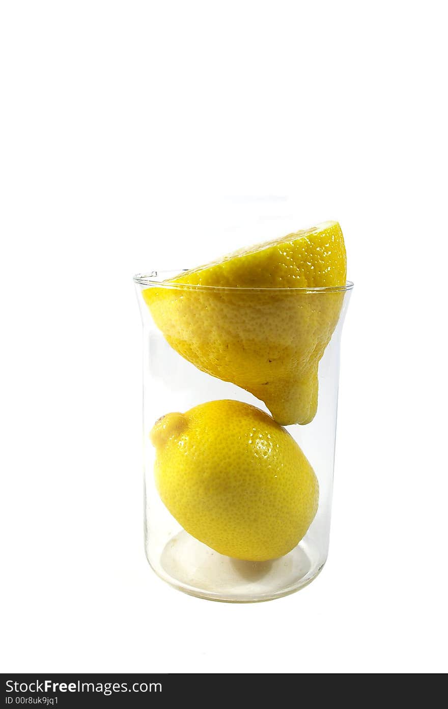 Two parts of yellow ripe lemon in the glass on white background