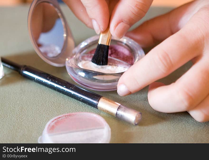 Brush for a make-up in hands at the visagiste, a shadow and a pencil. Brush for a make-up in hands at the visagiste, a shadow and a pencil