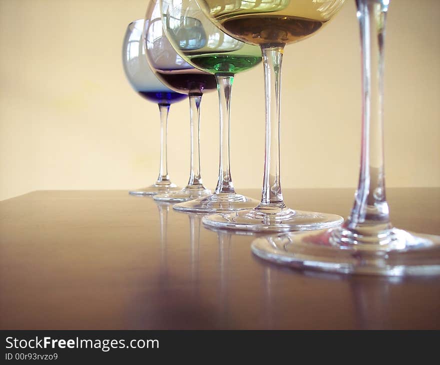 Different colored wine glasses arranged in different formations