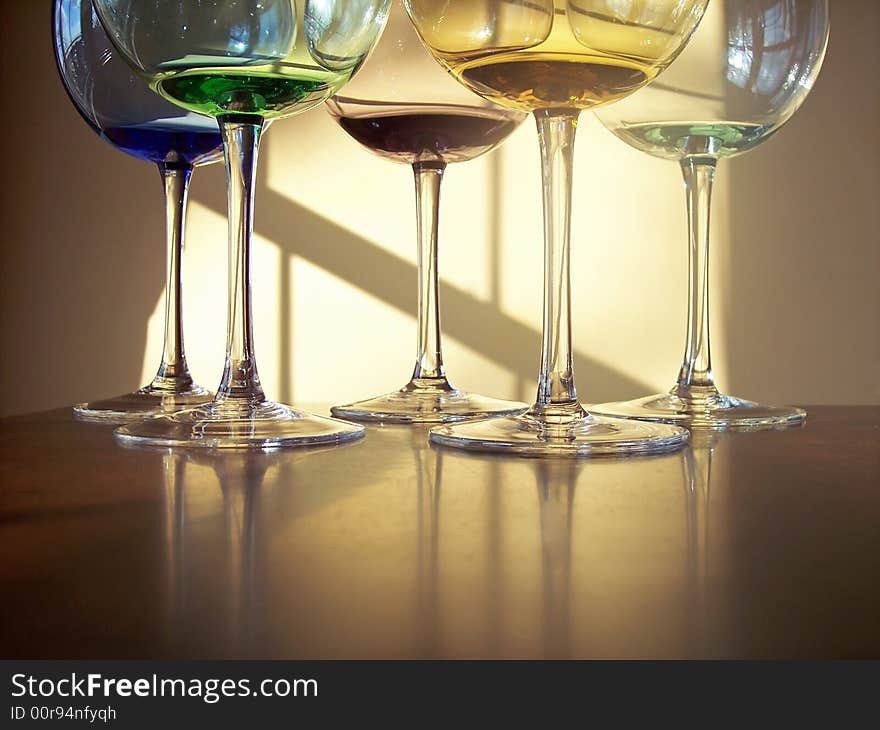 Different colored wine glasses arranged in different formations