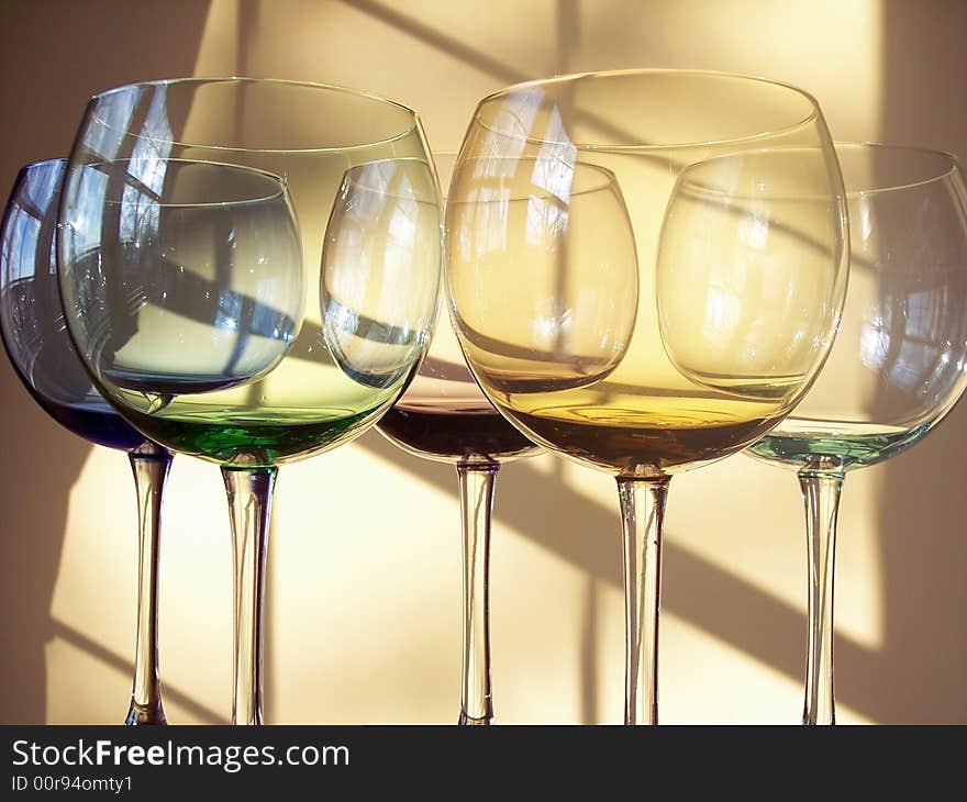 Different colored wine glasses arranged in different formations