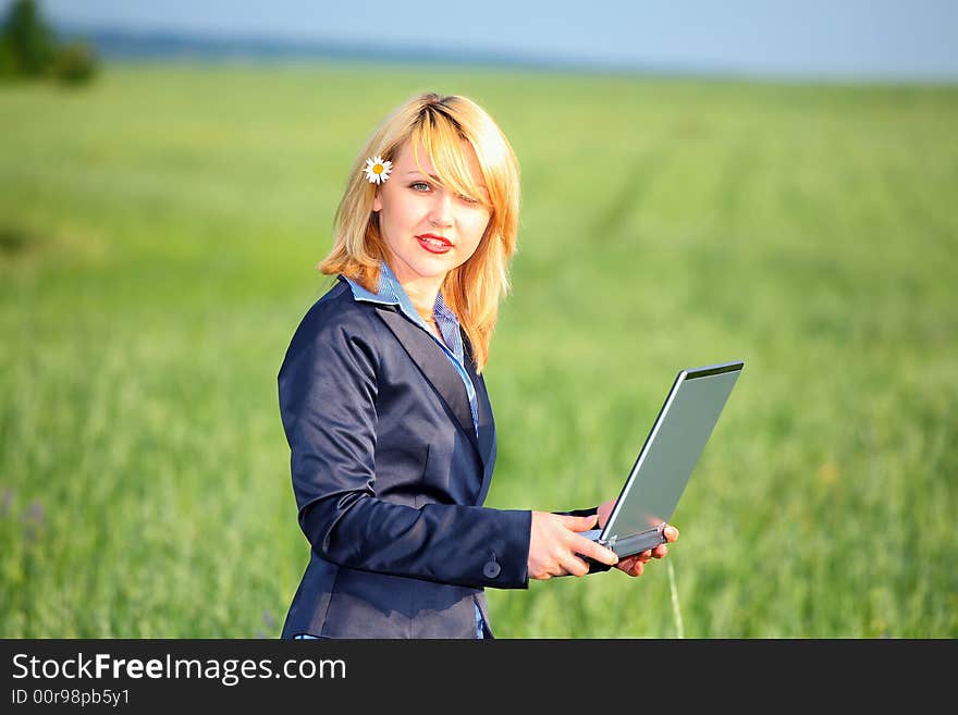 Girl with laptop stay on meadow