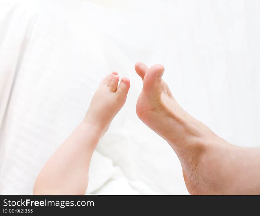 Baby's leg touch to father's leg. Connection people. Over white. Baby's leg touch to father's leg. Connection people. Over white